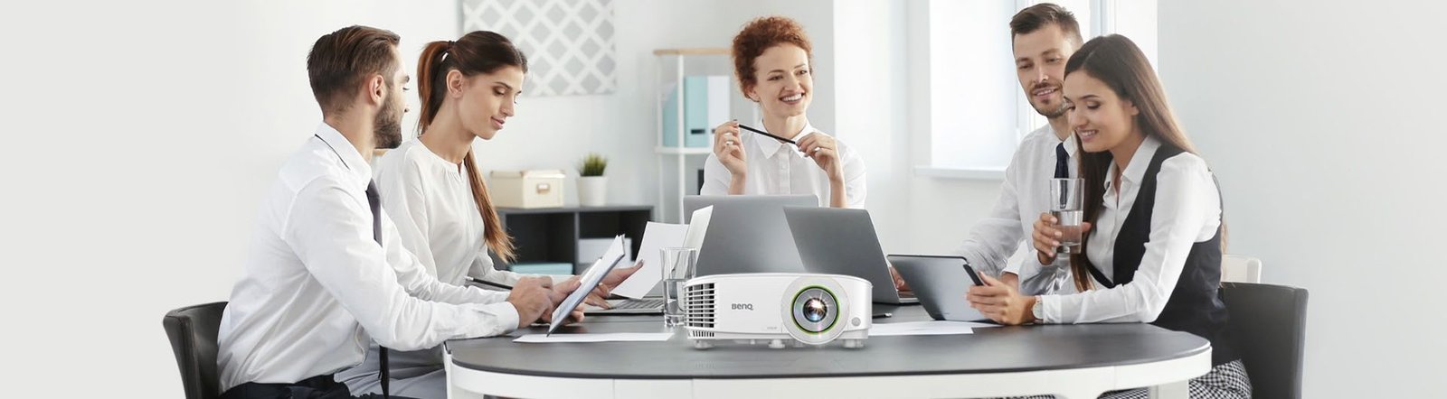 Team in a meeting room using a BenQ projector on a conference table